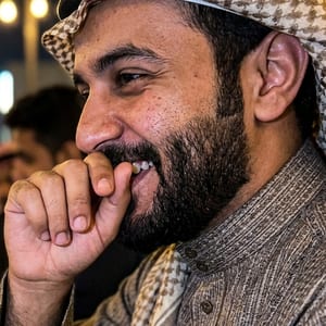 شاب يضحك ويغطي فمه بيده